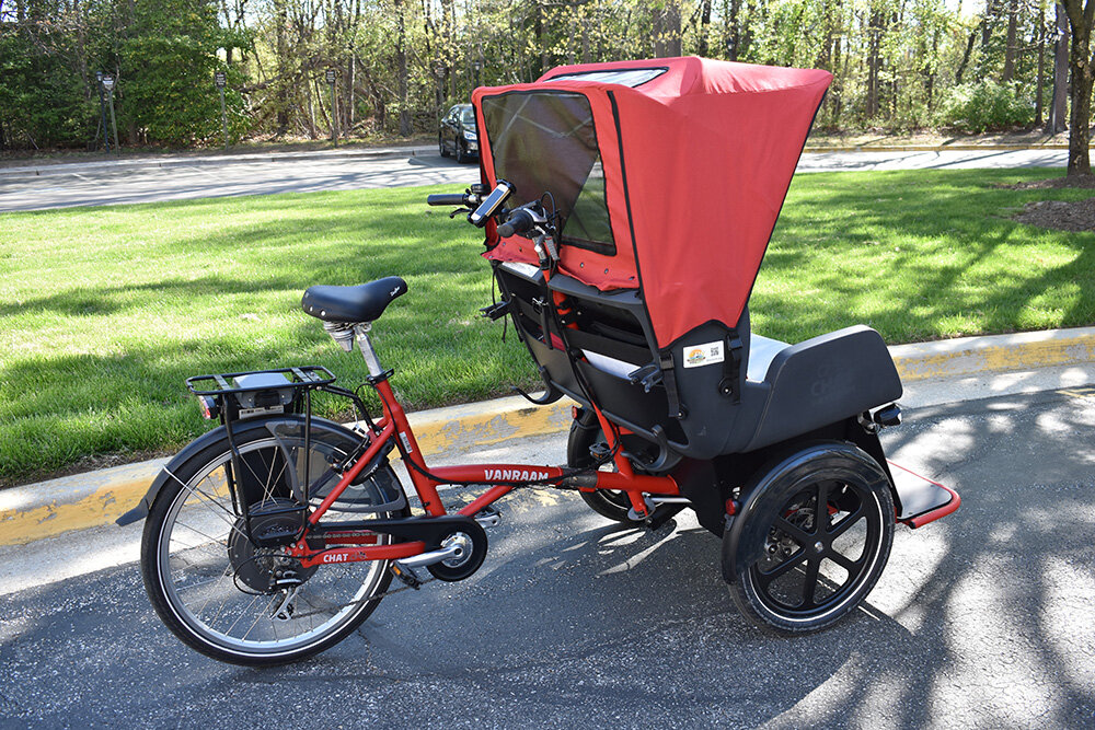 The trishaw carries two passengers and is driven by a volunteer pilot.