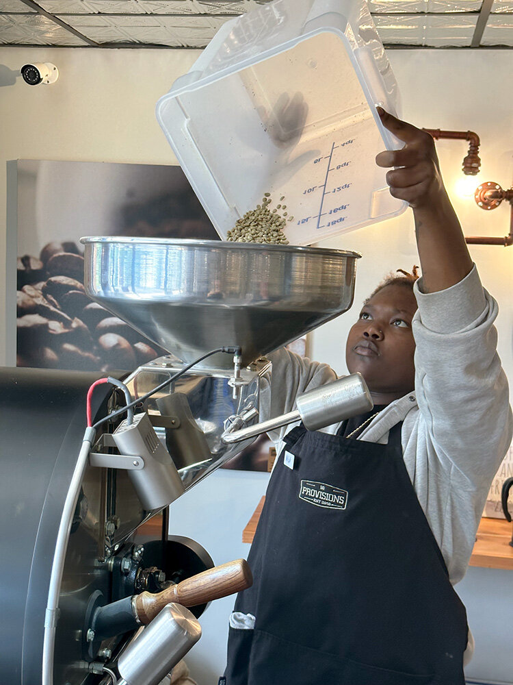 Nyla Everett, assistant manager at BD Provisions in Severna Park, poured beans into the roasting machine.