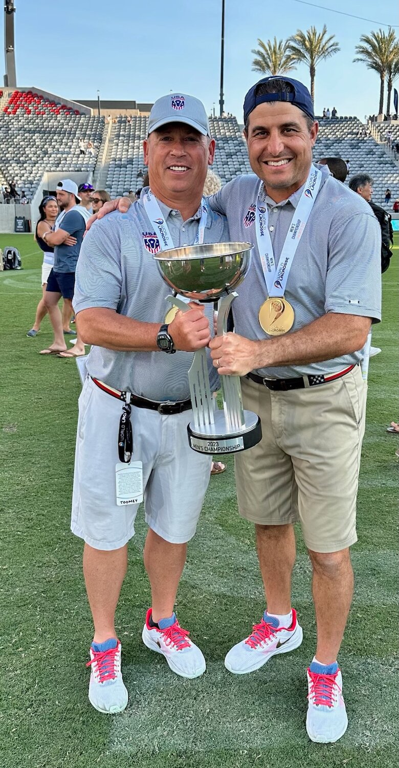 Loyola’s head lacrosse coach Charley Toomey, left, of Millersville held the men’s world championship trophy with Navy men’s lacrosse coach Joe Amplo of Severna Park.