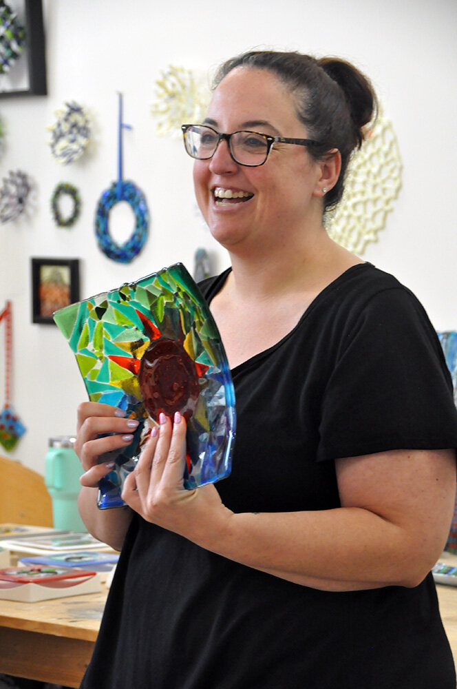 Clare Shepherd introduced herself and showed a shape design to participants of an August 17 glass fusing workshop for veterans at Maryland Hall.