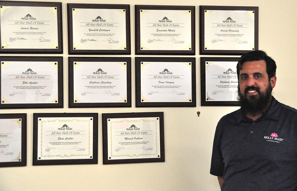 Michael Reilly, partial owner and general manager of Molly Maid of Central Anne Arundel County, pointed out certificates showcasing his company’s Excellence in Action All Star Hall of Fame national award winners. The award is a national competition open to all Molly Maid franchises.